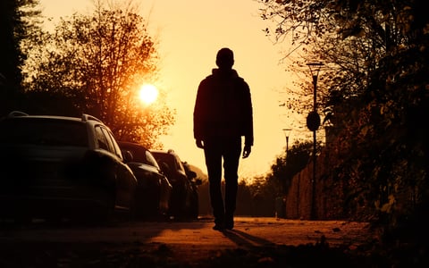 Persona caminando hacia el sol